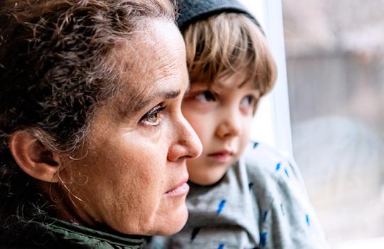 A woman and her son look out a window